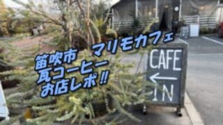 木の植物の隣にカフェの看板と、後ろにはダイニングのお店